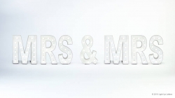 White marquee letters spell "MRS & MRS" against a light background.