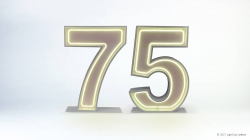 Illuminated neon-style number 75 on a light background.