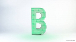 A large green, illuminated letter "B" with a metallic trim stands against a white background. Light bulbs are embedded in the letter.