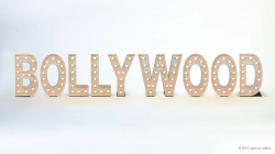 The image shows large, illuminated letters spelling "BOLLYWOOD" against a plain background.