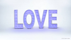 The image shows the word "LOVE" in large, illuminated letters with a white background.