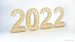 Illuminated numbers forming "2022" with small lights against a light background.