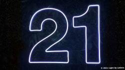 Neon light display of the number 21 against a dark background.