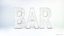 Illuminated marquee letters spelling "BAR" against a plain background.