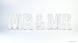 The image shows illuminated letters spelling "MR & MR" against a white background.